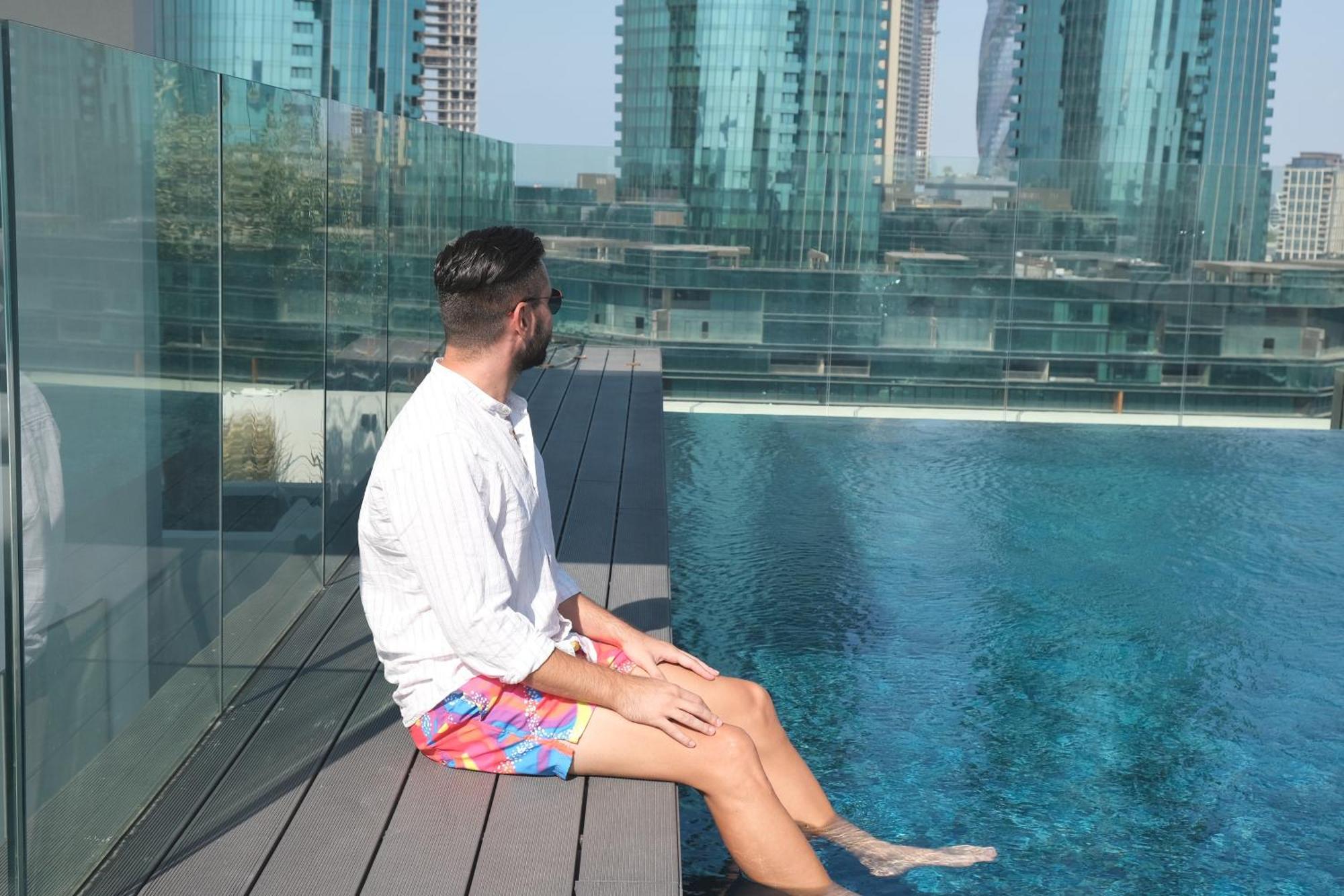 麦纳麦 Charthouse Bahrain酒店 外观 照片 A man sitting on the edge of a pool